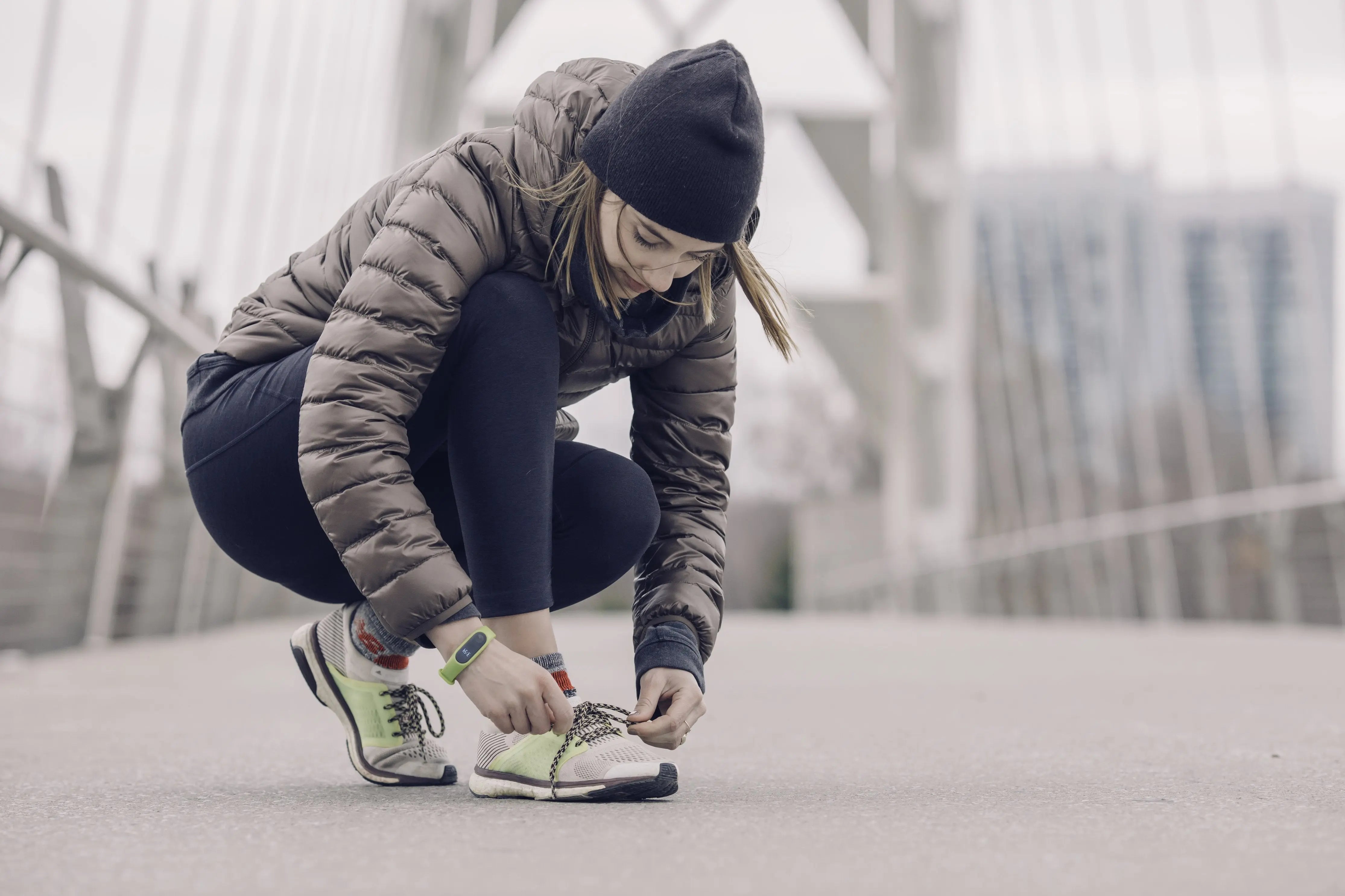 Woman outside exercising and tying her show on a bridge