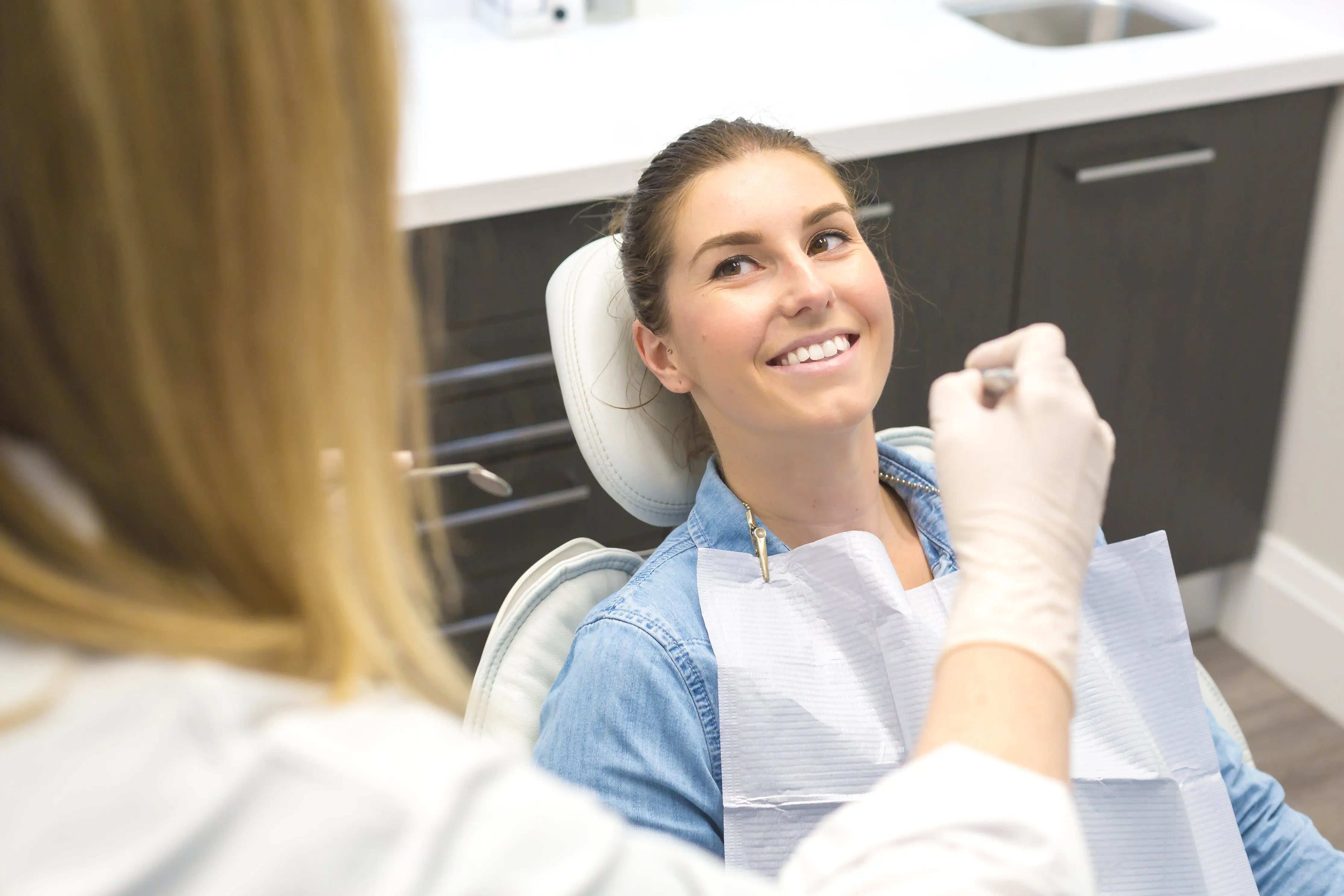 Patient with smile in dentist chair discussing oral microbiome