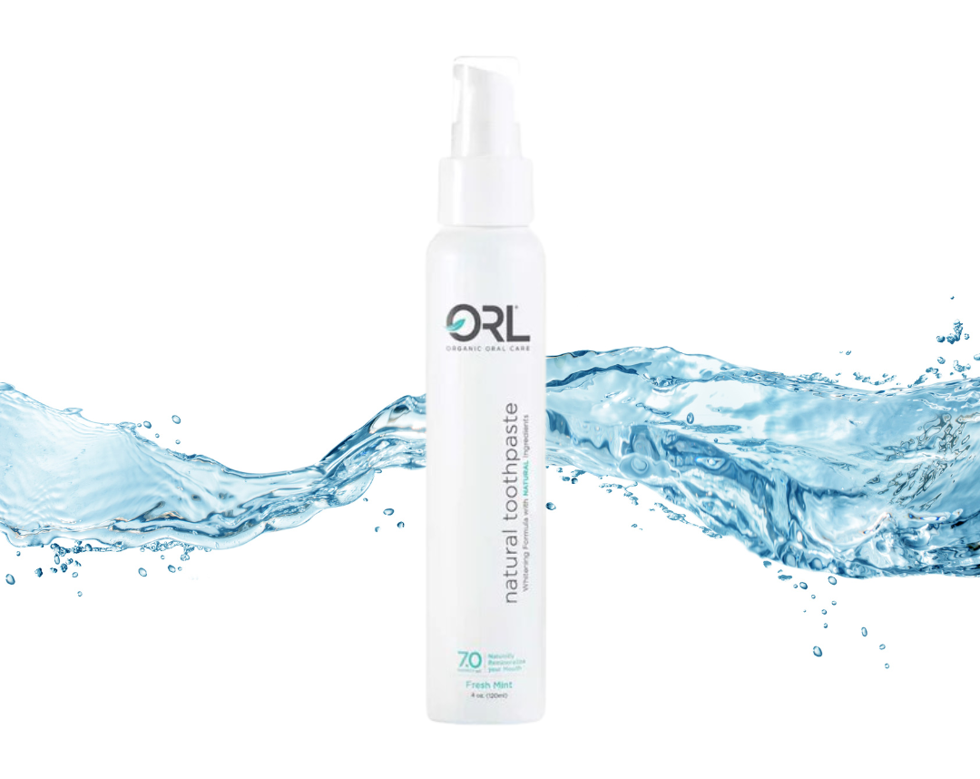 Eco-friendly aluminum white bottle of ORL toothpaste with a splash of water running behind it.