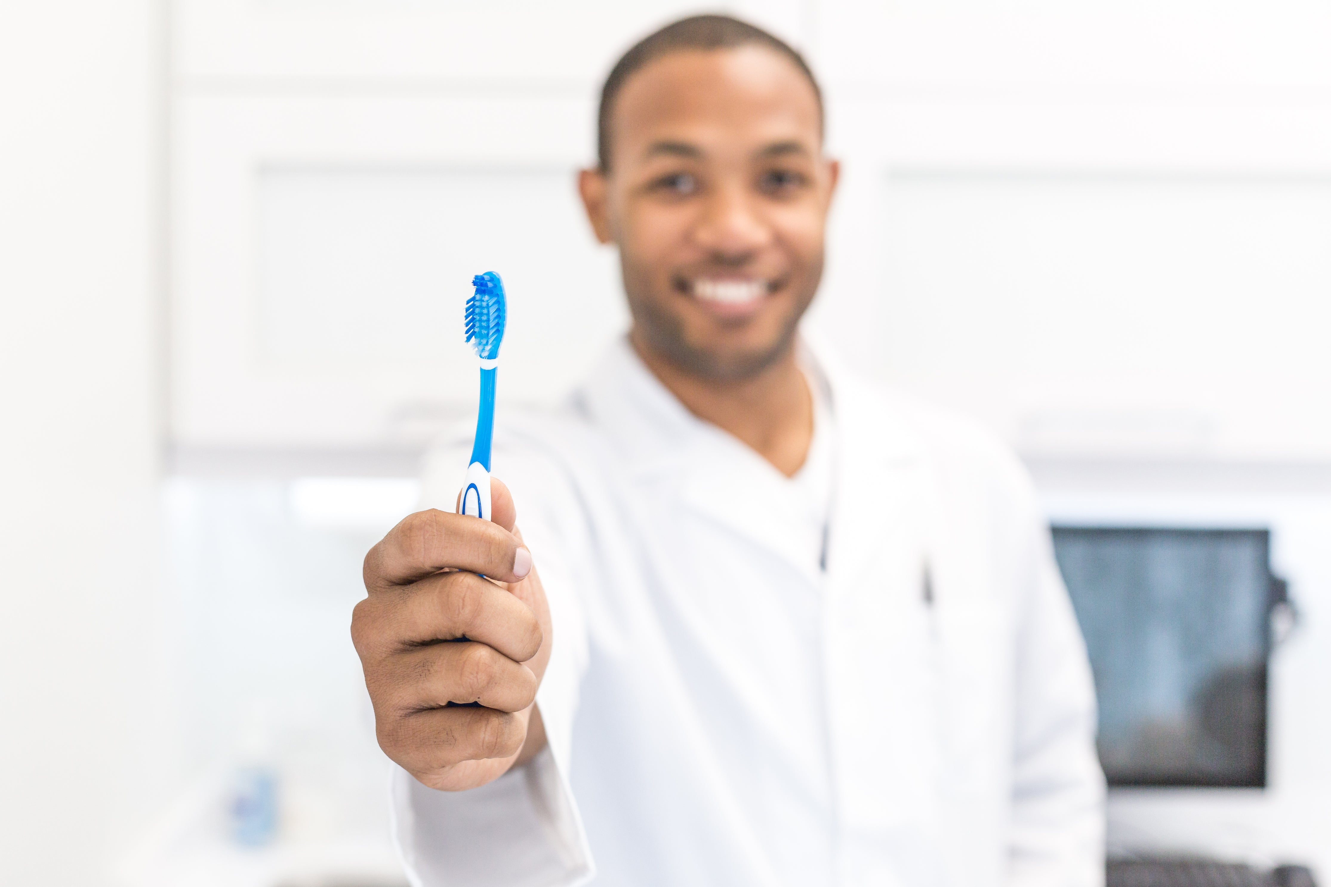 Natural Dentist Smiling with Toothbrush and Fluoride-free Toothpaste 